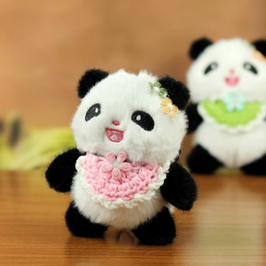 Detailaufnahme des Panda-Plüschtiers mit rosa Spitzenlatz und floralem Kopfschmuck