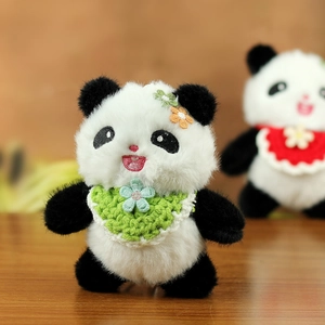Nahaufnahme von Plüsch Panda Schlüsselanhänger mit grünem Lätzchen und Blumendekor