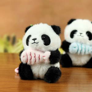 Dettagli di portachiavi panda di peluche con pesci colorati su un piano in legno
