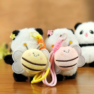 Detail of plush panda charms with bee backpacks and colorful flower accents on wood