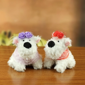 Detail of two white plush Westie dogs with purple and red floral lace decorations