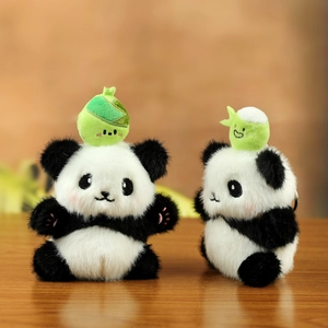 Detail of two plush panda keychains with soft faux fur and bamboo head decoration