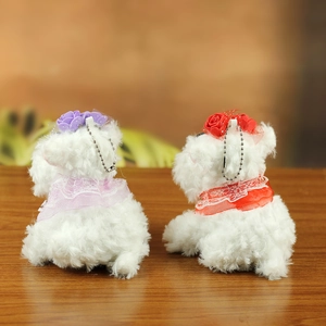 Detailed view of plush puppy keychains with lace collars and floral accessories on wood