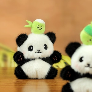 Close-up of cute plush panda keychain featuring soft fur and small green bamboo shoot