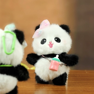 Gros plan du porte-clés panda en peluche avec nœud rose et détail de mini biberon coloré
