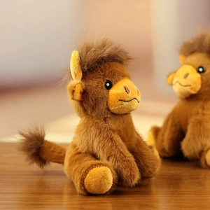 Detailed view of plush camel keychain showing fuzzy faux fur texture and embroidered face