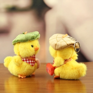 Plush yellow duck keychains with cute green beret and red heart bag on a cozy background