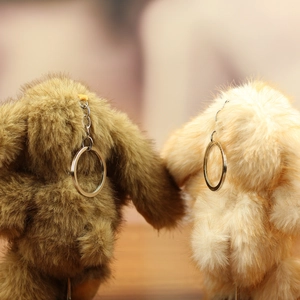 Detail of plush faux mink rabbit charms in brown and beige with silver keyrings
