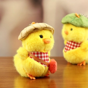 Detail of plush yellow duck keychain with red scarf and striped hat accessory