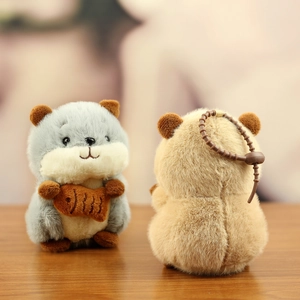 Close-up of soft plush hamster keychain featuring grey and brown fur with fish detail