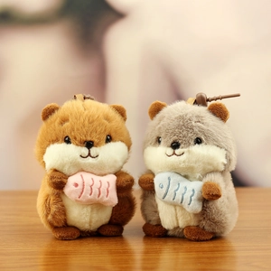 Cute plush hamster keychain charms in brown and grey holding small embroidered fish
