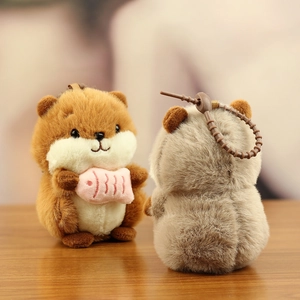 Close-up of cute plush hamster keychain with fluffy texture and small pink fish detail