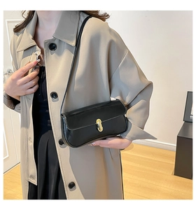 Classic black baguette bag with gold metal buckle worn with a beige trench coat
