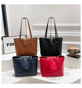 Detail of multi-color tote bags with gold V-hardware and lychee grain leather texture