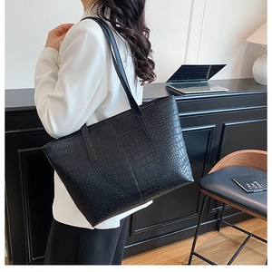 Close-up of black crocodile pattern large tote bag with top handles for commuting