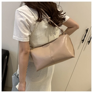 Detail view of stylish beige hobo bag with knotted shoulder strap and sleek PU leather finish