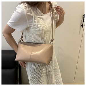 Minimalist beige leather shoulder bag shown on model for size and outfit styling