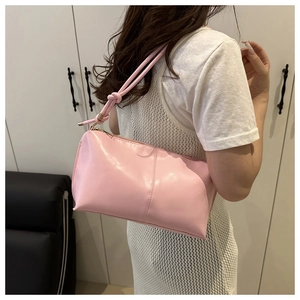 Gros plan sur le sac sous l'aisselle rose minimaliste avec bandoulière à nœuds