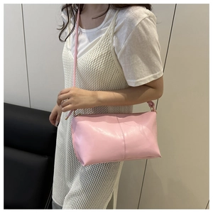 Detail of soft pink faux leather shoulder bag with fine stitching and gold hardware