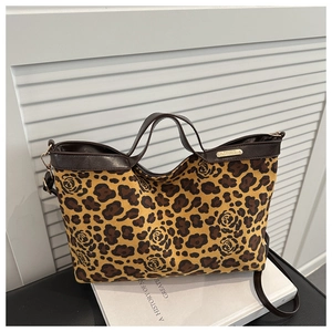 Detail of leopard and rose print canvas handbag with brown leather handles and gold logo