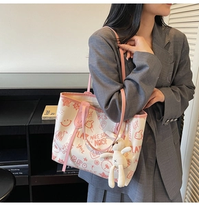 Vue latérale d'un sac cabas en toile avec graffitis blancs, bords roses et lapin