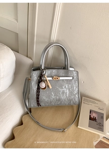 Gros plan du sac rétro argenté avec fermoir doré et pendentif de baseball chic
