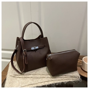 Detail of dark brown lychee leather bucket bag with silver lock and matching pouch