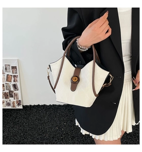 Detail of contrast bucket bag with retro gold twist lock and elegant top handle