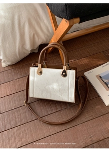 Détail du sac rétro minimaliste en velours côtelé blanc avec finitions en cuir marron