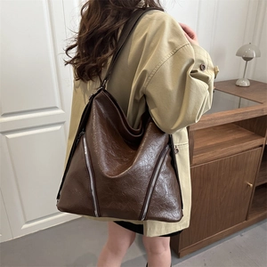 Grande borsa tote retrò in pelle marrone con cerniere decorative mostrata sul modello