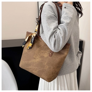 Detailed view of brown textured tote bag featuring a decorative vintage floral silk scarf