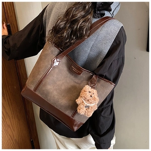 Détail du sac cabas en daim avec motifs embossés et un joli porte-clés ours en peluche