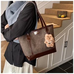 Détail d'un sac cabas en daim avec texture ours en relief et finitions marron foncé