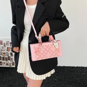 Pink luxury handbag with embossed floral patterns and silk scarf handle decoration