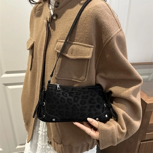 Chic black leopard print shoulder bag with silver hardware and ribbon side details