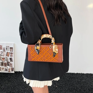 Brown leather handbag with orange rope embroidery and silk scarf handle decoration