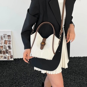 Minimalist white and brown trapezoid bucket bag with retro metal twist lock