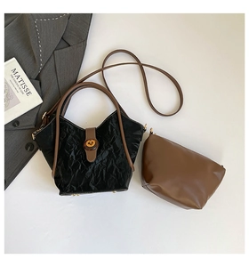 Detail of black pleated bucket bag with brown inner pouch and vintage gold lock