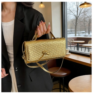 Macro detail of golden woven texture on flap handbag with stylish knot hardware detail