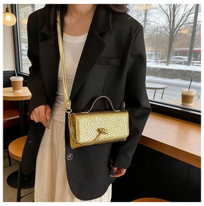 Close-up of golden woven texture and metal knot buckle on a vintage handbag