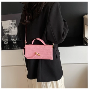 Detailed view of pink woven leather texture and elegant gold knot twist lock closure