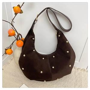 Detail der dunkelbraunen Hobo-Tasche aus Wildleder mit goldenen Nieten und Reißverschluss