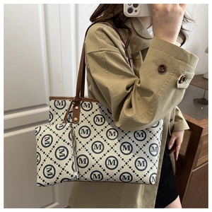 Detail of printed canvas tote bag set with monogram logo and matching small pouch