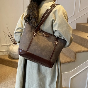 Grand sac cabas marron à motifs chats, porté par un mannequin dans un escalier intérieur