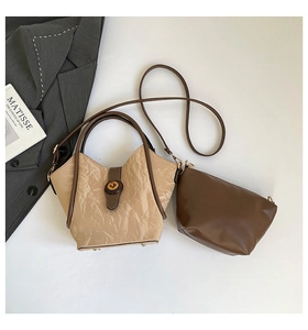 Flat lay of pleated bucket bag and inner pouch with golden twist lock and brown straps