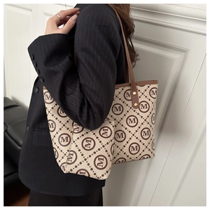 Detail view of canvas tote bag and mini pouch set with M print on stripe blazer model