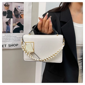 Detail van witte leren handtas met gouden gesp en gevlochten kettingriem voor dames mode