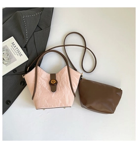Top view of a pink pleated bucket bag with brown straps and a matching inner pouch