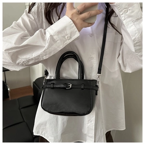 Mini black PU leather crossbody bag with silver buckle shown in mirror selfie