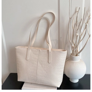 Close-up of cream crocodile pattern tote bag featuring premium embossed texture details